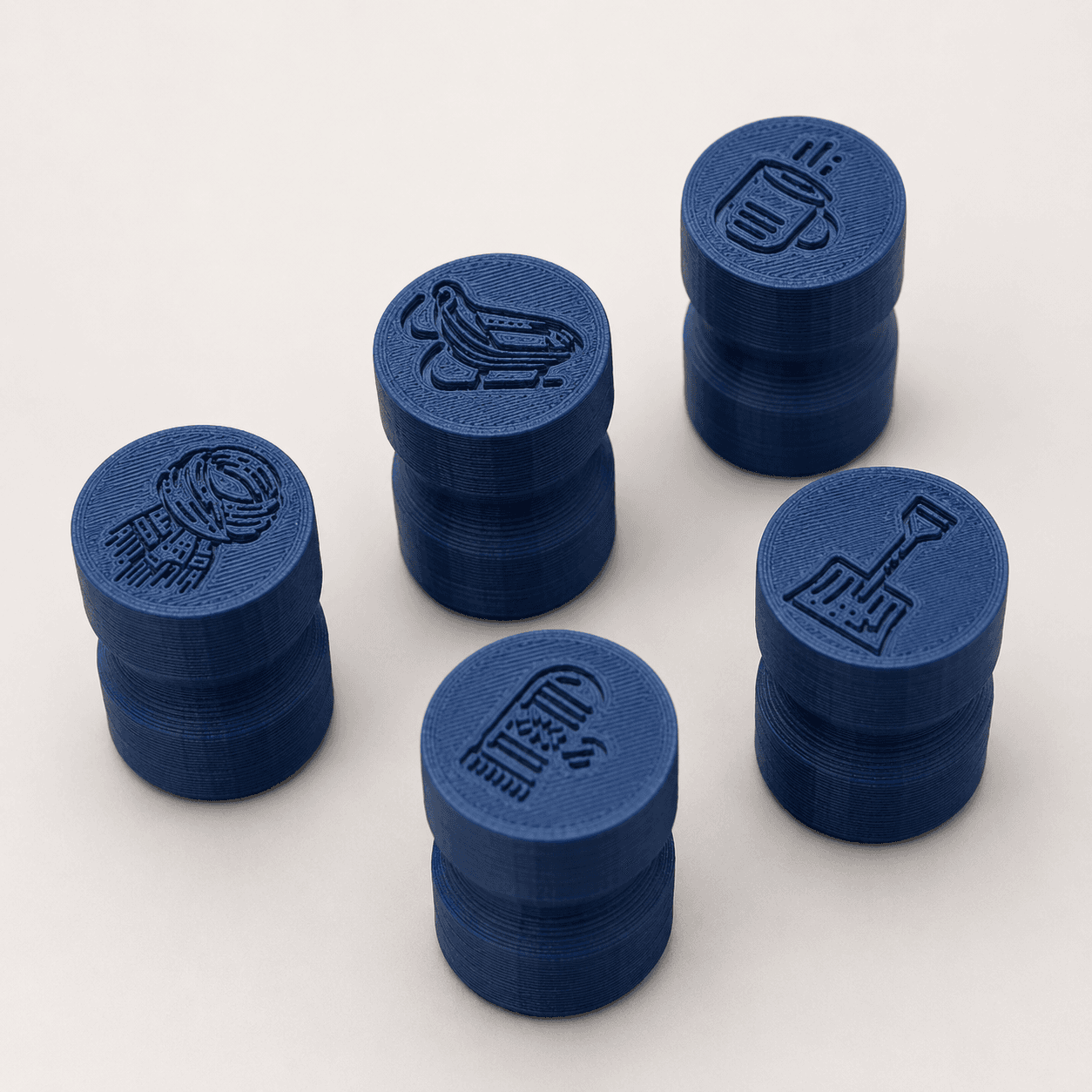 Blue 3D printed stamp handles with maker-tool designs